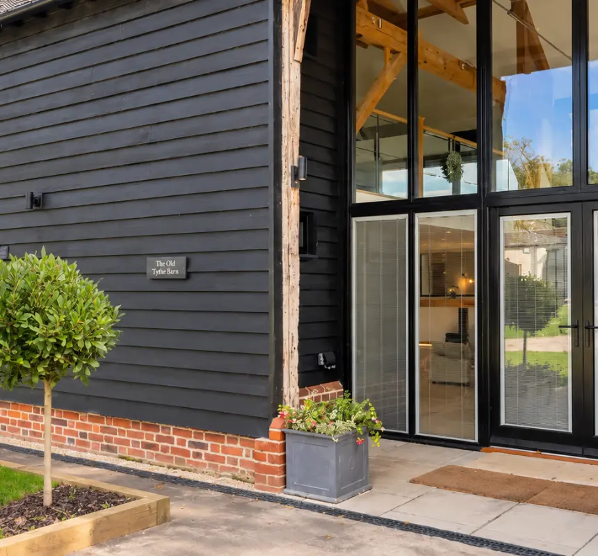 Black weatherboarded barn with full height glazed entrance doors, made by Spittlywood