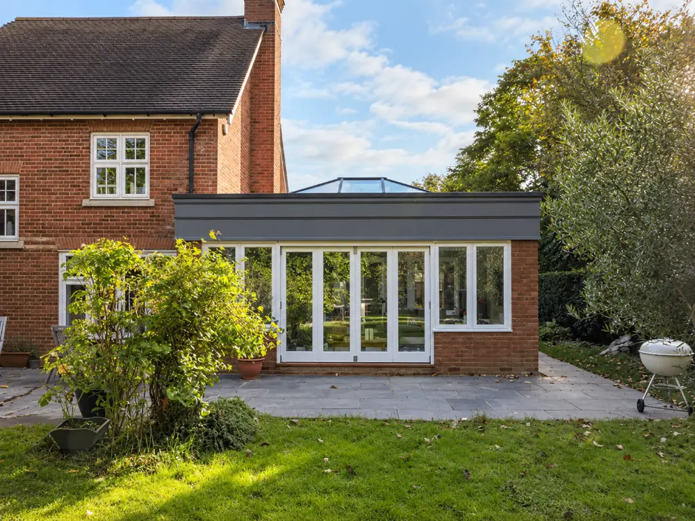 Timber orangery with bifold doors on a brick house, made by Spittlywood
