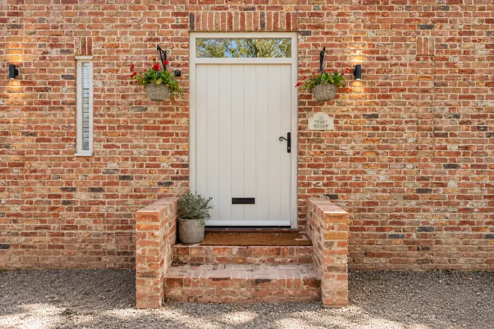 Cream timber front door with brick steps, made by Spittlywood