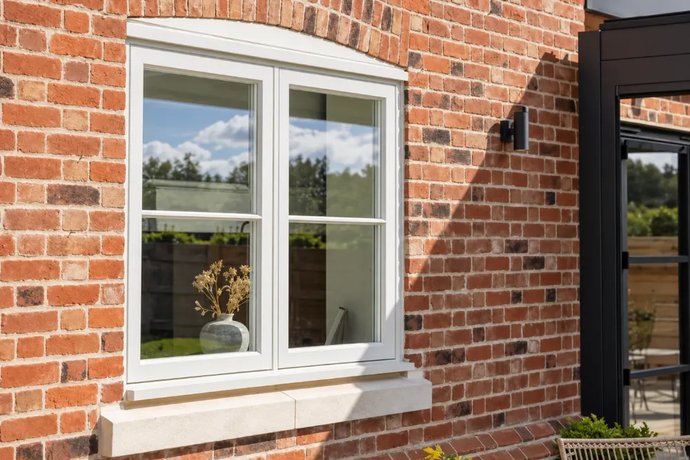 White timber casement window in a red brick wall, made by Spittlywood
